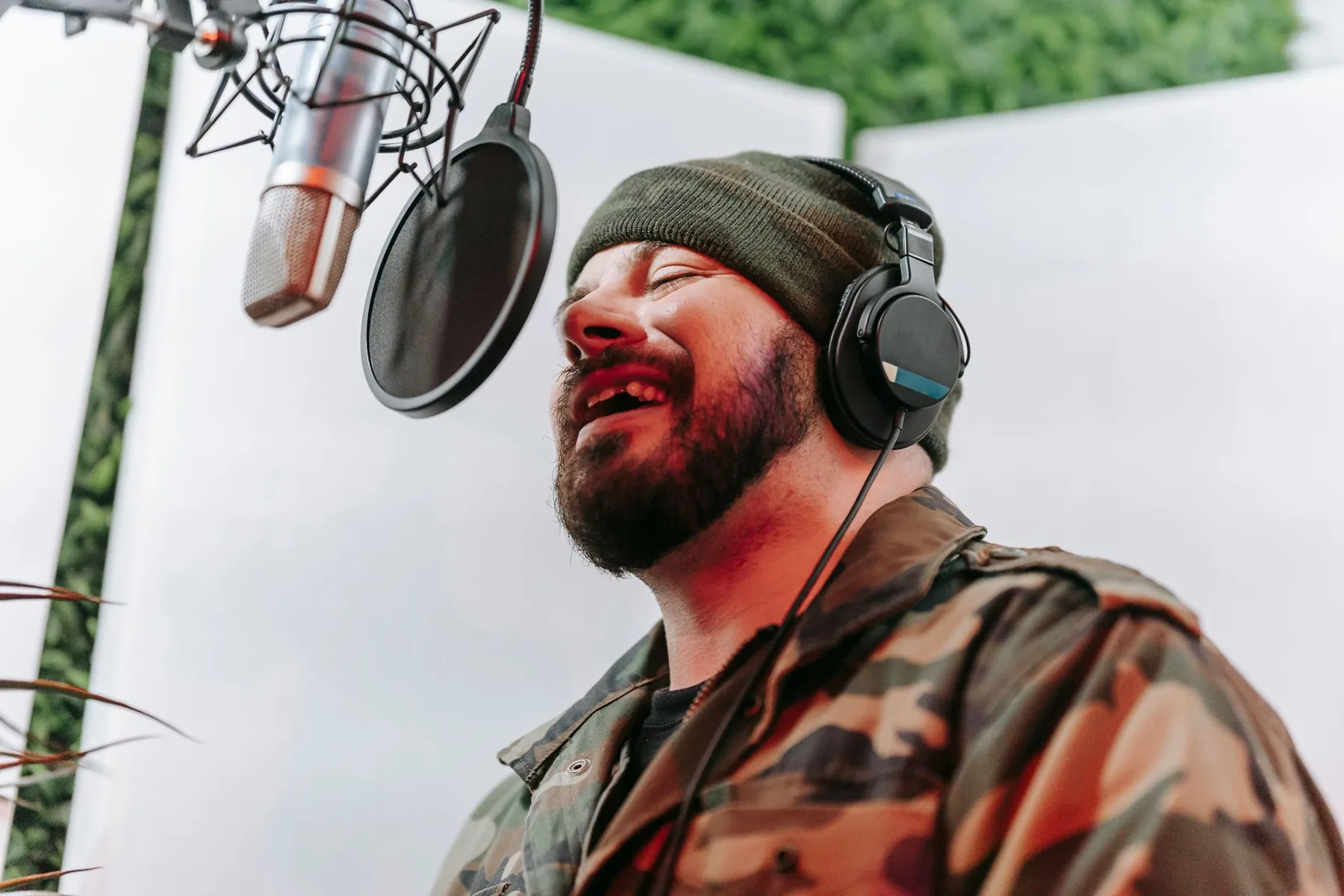singer with headphones in front of a studio microphone singer with headphones in front of a studio microphone