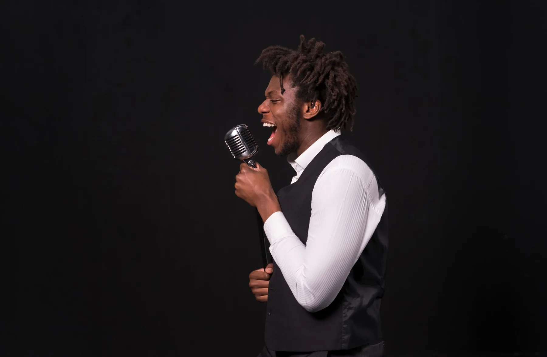 singer with microphone against a black background singer with microphone against a black background