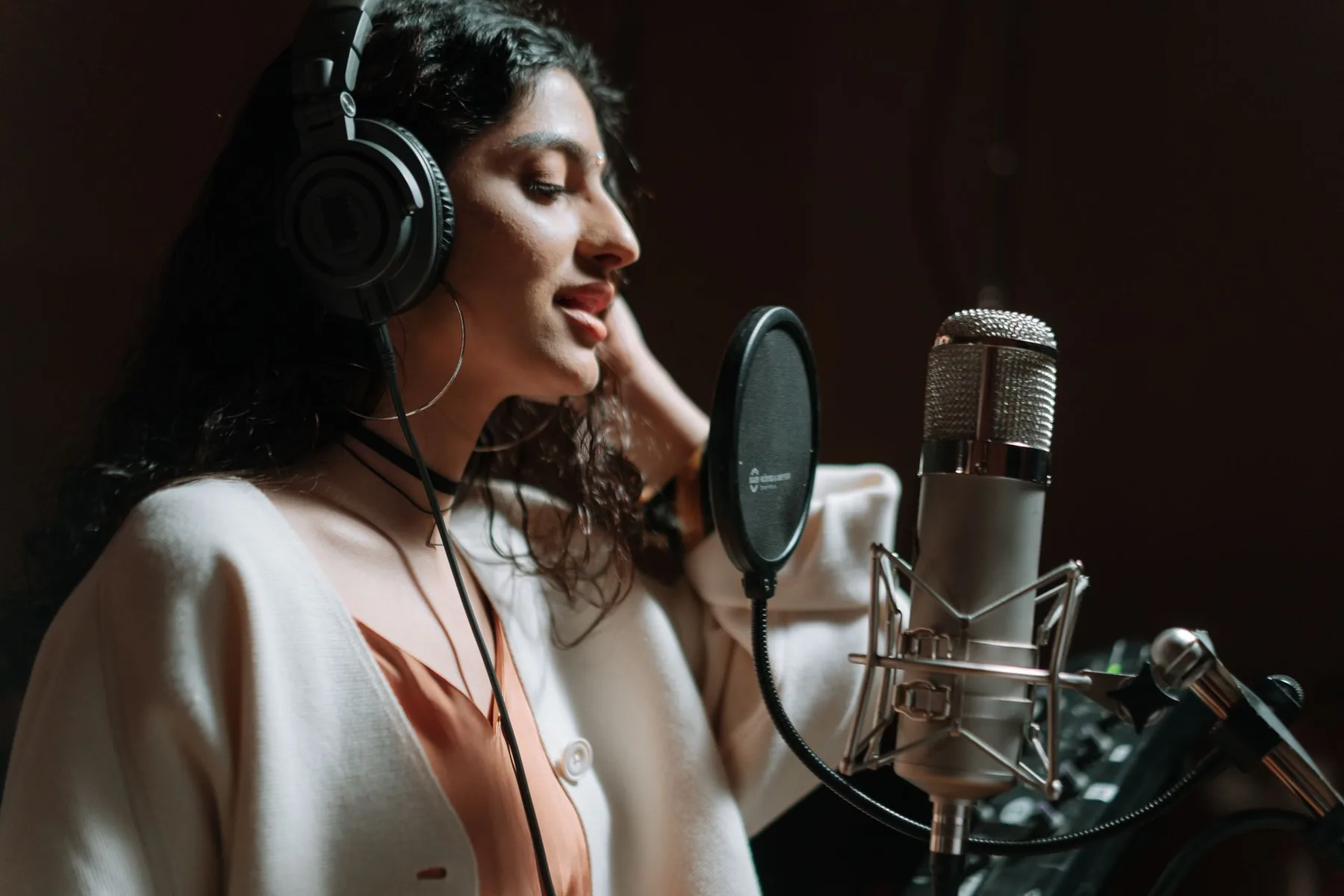 singer at a microphone in a studio